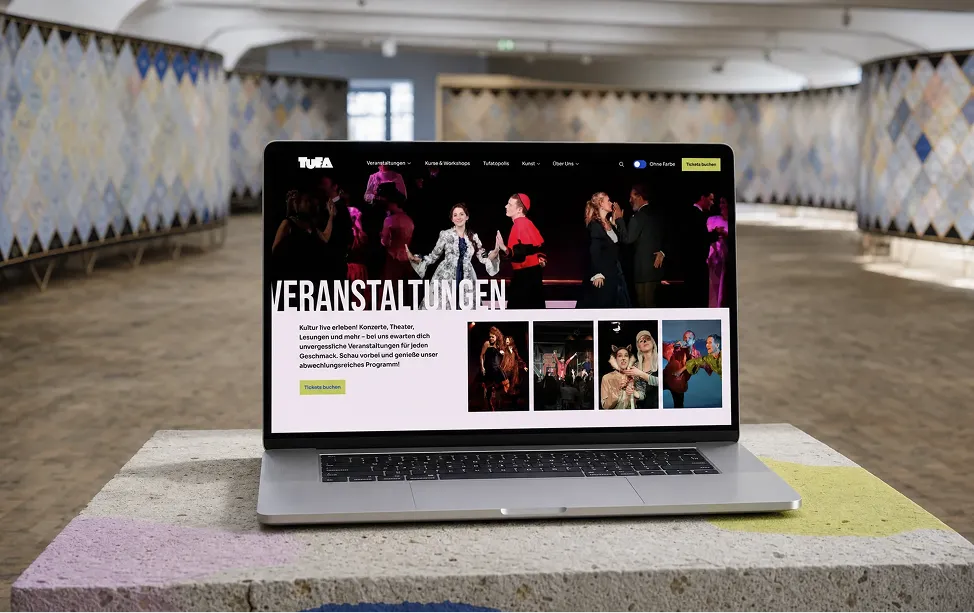 Laptop displaying the TUFA website in the cultural center foyer