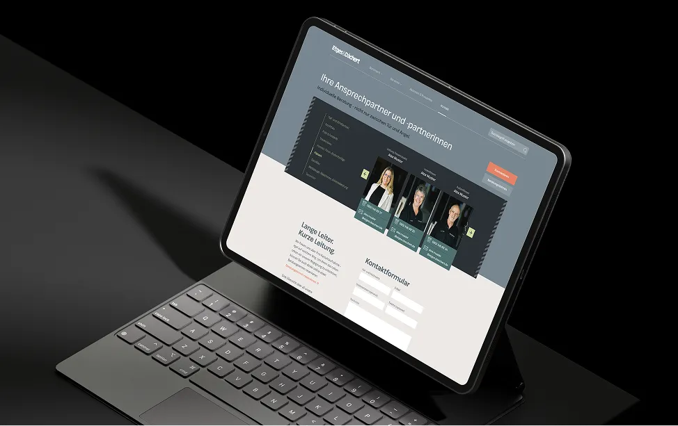A Surface tablet with a keyboard displays the contacts page of the Etges & Dächert website.